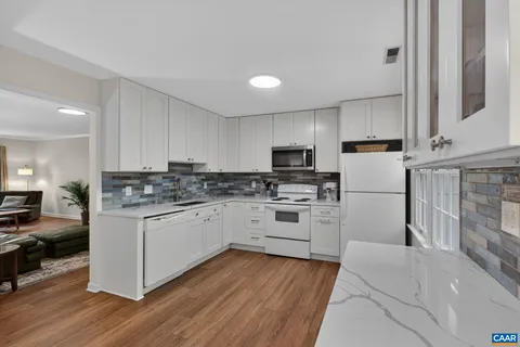 a kitchen with granite countertop white cabinets and white appliances
