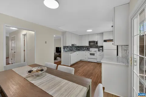 a living room with stainless steel appliances granite countertop furniture and a view of kitchen