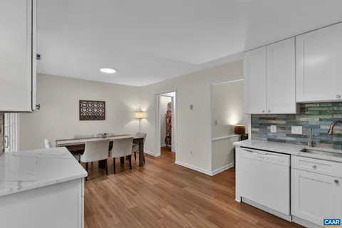 a kitchen with a sink a stove cabinets and wooden floor