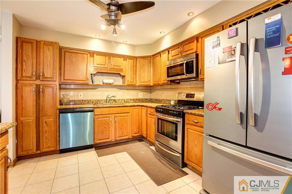 4 Laythan Road Edison, NJ 08817 - Photo 8 of 25 a kitchen with stainless steel appliances granite countertop a refrigerator a stove and a sink with wooden floor