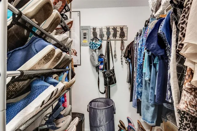 a view of walk in closet with clothes and shoes