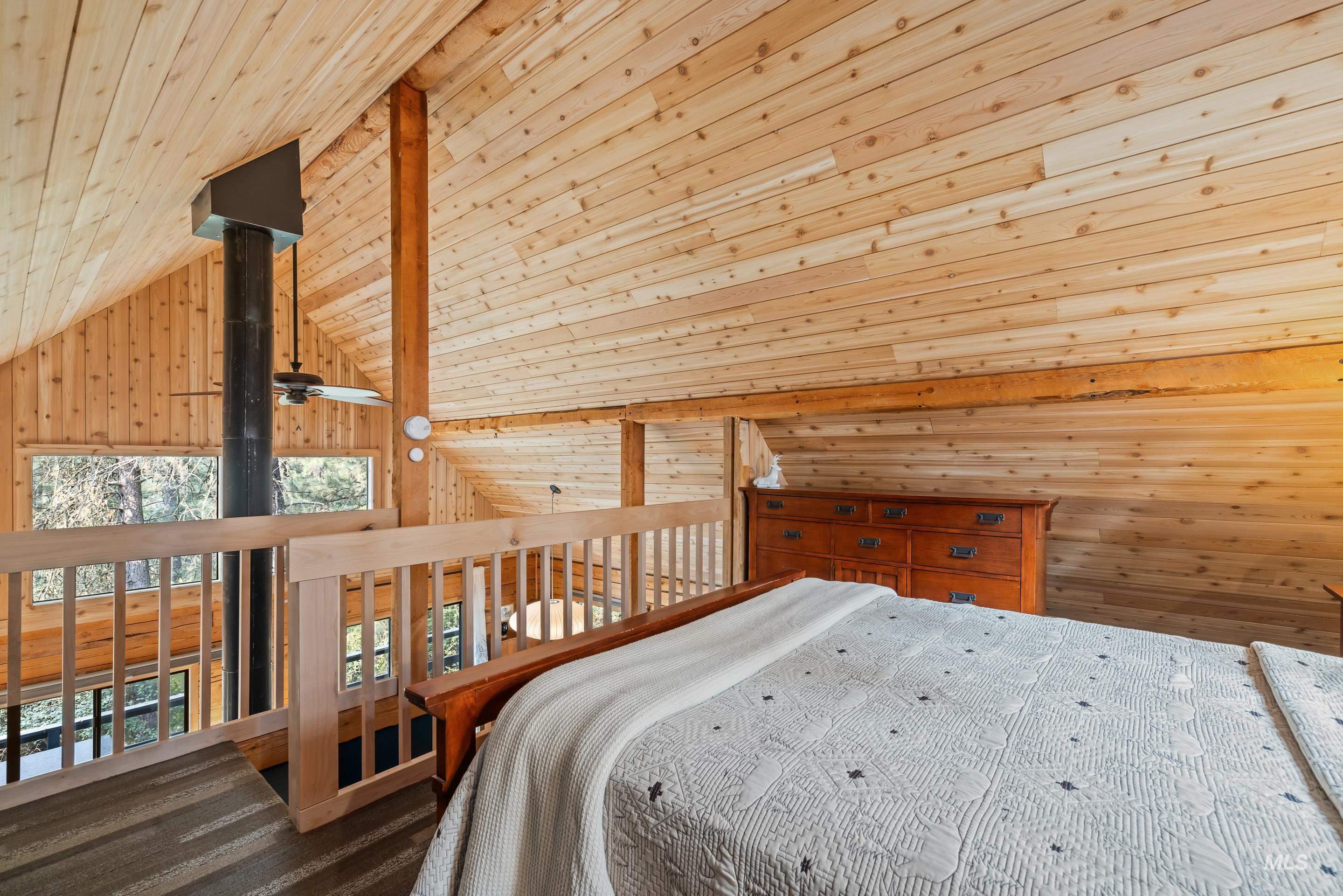 73 Rainbow Ridge Road Garden Valley, ID 83622 - Photo 33 of 49 Vaulted wood-paneled ceilings, natural wood wall finishes, exposed structural beam, wood railing, and integrated ceiling fan