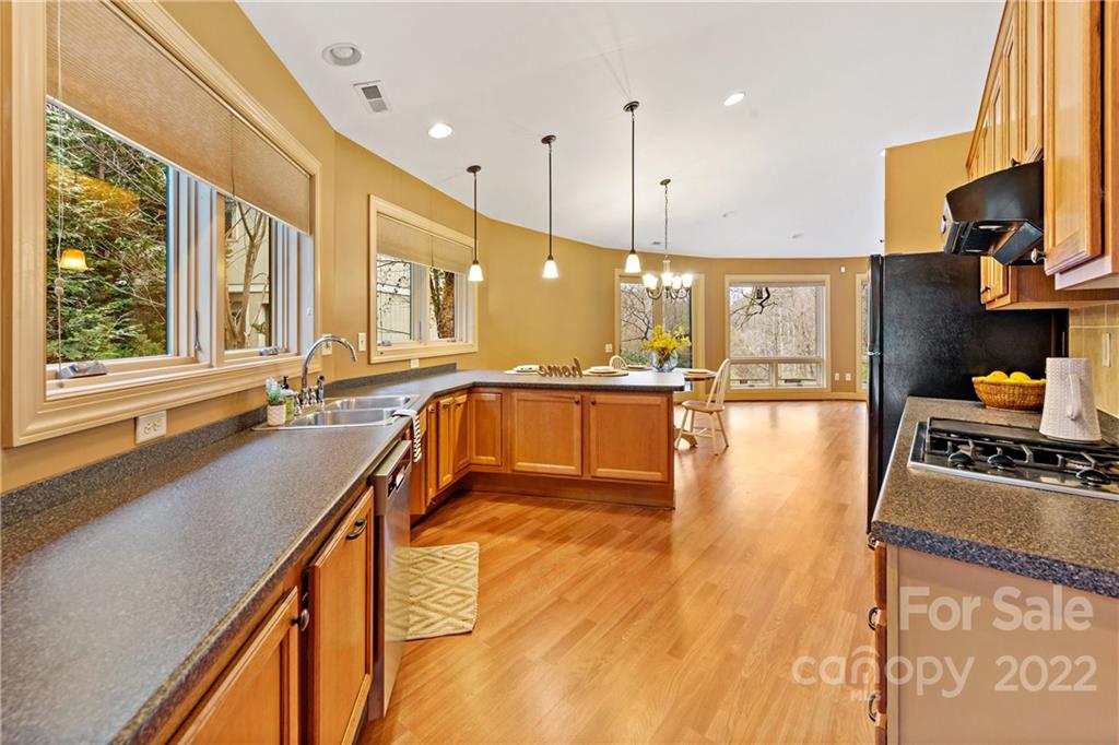 174 A Weston Road Arden, NC 28704 - Photo 9 of 31 a large kitchen with stainless steel appliances a large window and a wooden floor