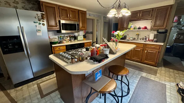 a kitchen with stainless steel appliances granite countertop a sink refrigerator and microwave