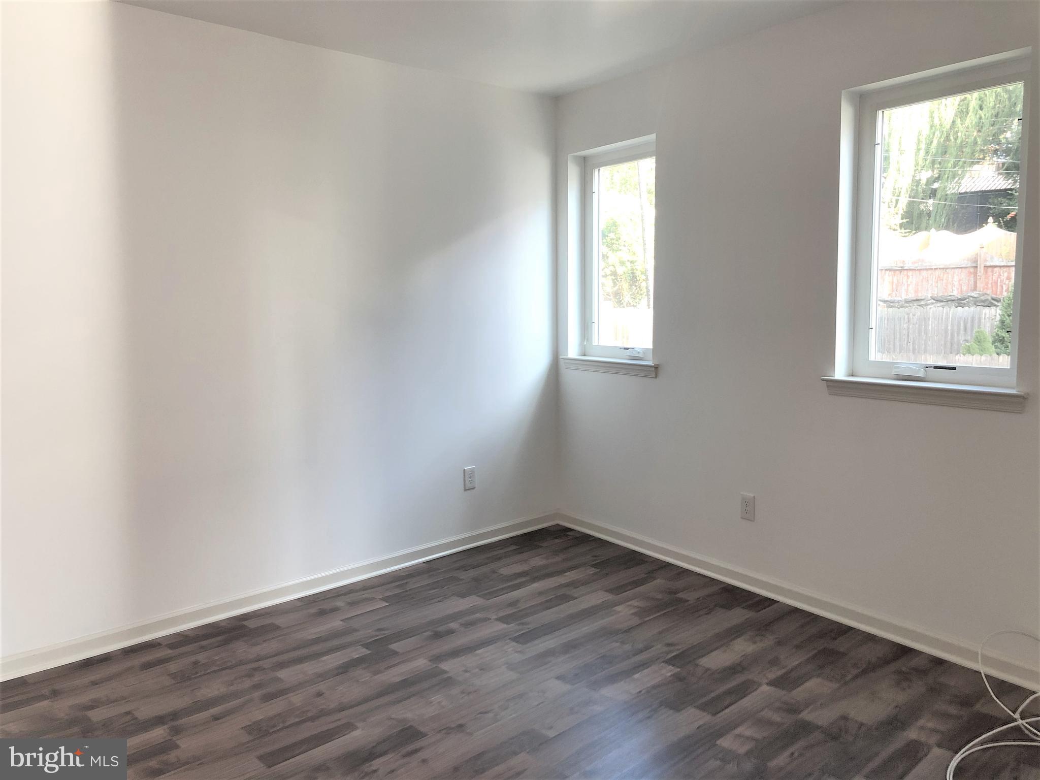 5261 Ridge Avenue, Unit 305 Philadelphia, PA 19128 - Photo 2 of 7 an empty room with wooden floor and windows