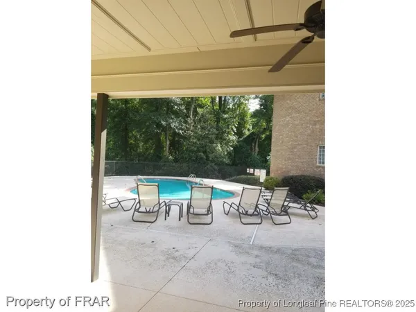 a view of a patio with a table and chairs under an umbrella
