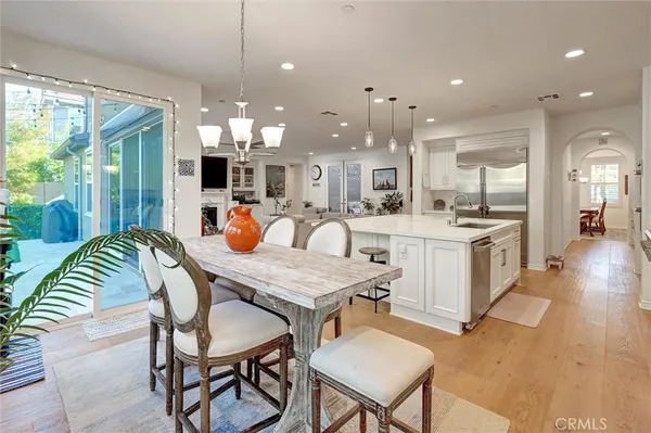 a living room with furniture kitchen view and a large window