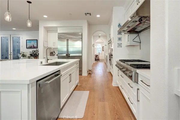 a kitchen that has a lot of white cabinets and couches