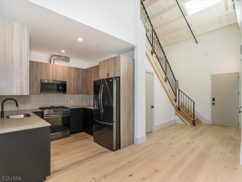 369 Bloomfield Avenue, Unit 2 Montclair, NJ 07042 - Photo 17 of 19 a kitchen with a sink a refrigerator and a stove top oven with wooden floor
