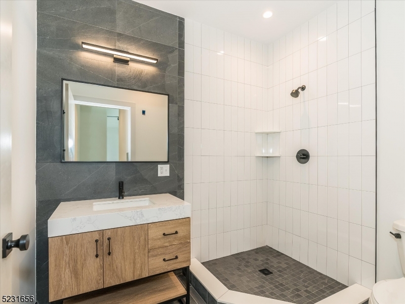 369 Bloomfield Avenue, Unit 2 Montclair, NJ 07042 - Photo 9 of 19 a bathroom with a sink a mirror and shower