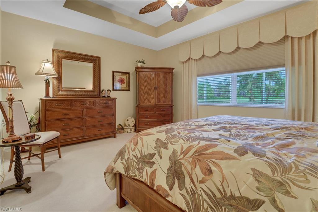 20531 Foxworth Circle Estero, FL 33928 - Photo 13 of 50 Bedroom featuring a tray ceiling, ceiling fan, and light colored carpet
