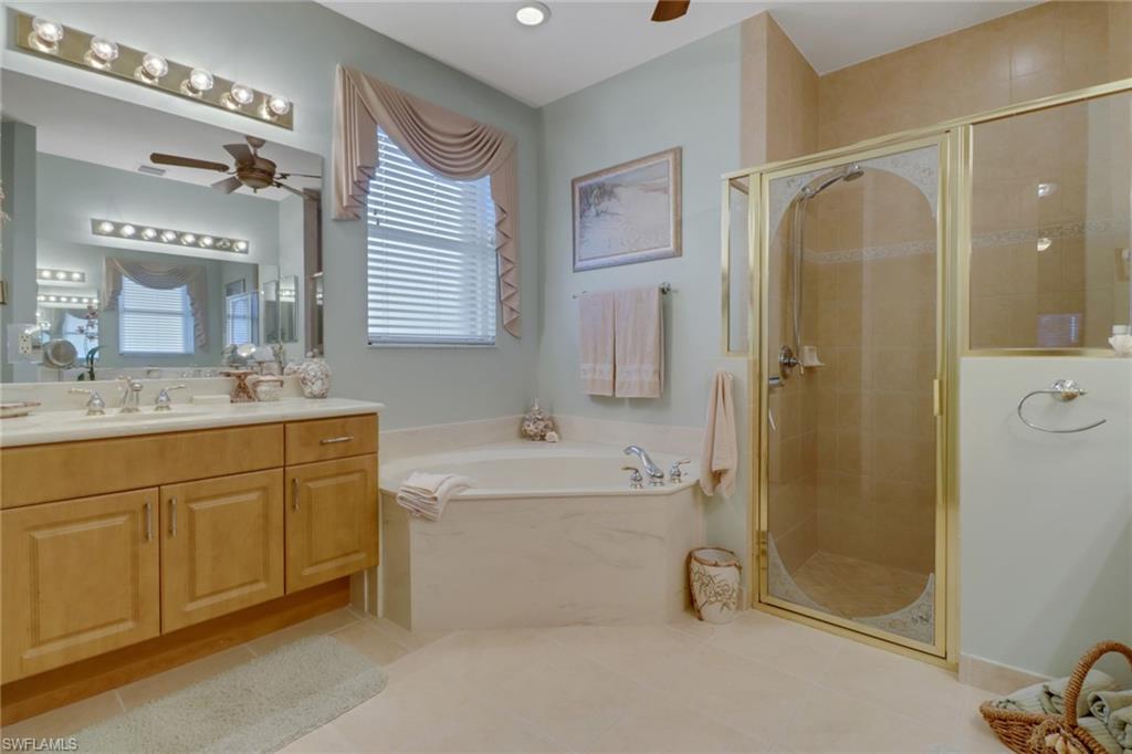 20531 Foxworth Circle Estero, FL 33928 - Photo 14 of 50 Bathroom with ceiling fan, tile patterned floors, plus walk in shower, and vanity