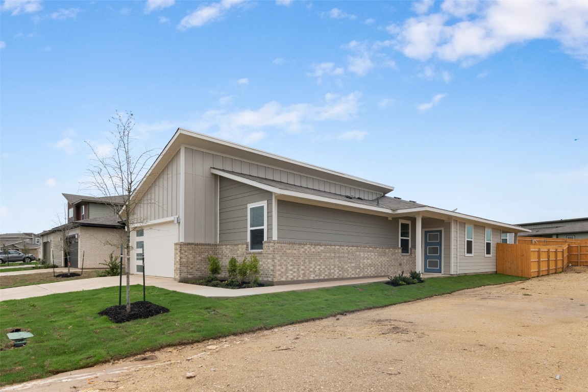 220 Deserti Road Leander, TX 78641 - Photo 1 of 16 Mid-century home with brick siding, a garage, concrete driveway, and board and batten siding