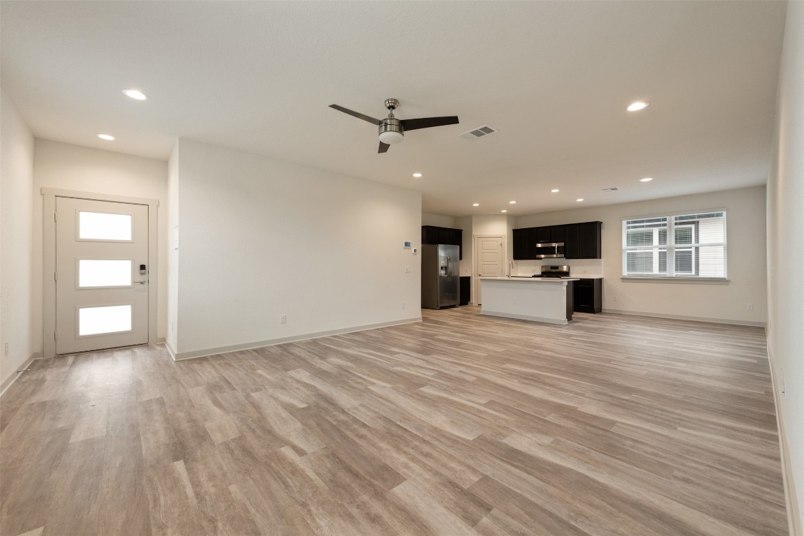 220 Deserti Road Leander, TX 78641 - Photo 3 of 16 Unfurnished living room featuring light wood-style flooring, recessed lighting, and a ceiling fan