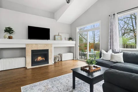 a living room with furniture a flat screen tv and a fireplace