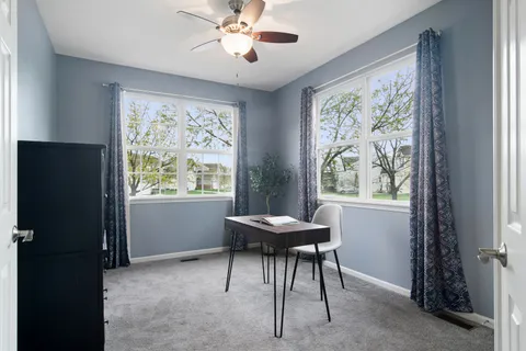 a view of a workspace with furniture and a window