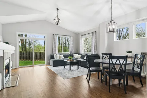 a dining room with furniture a chandelier and wooden floor