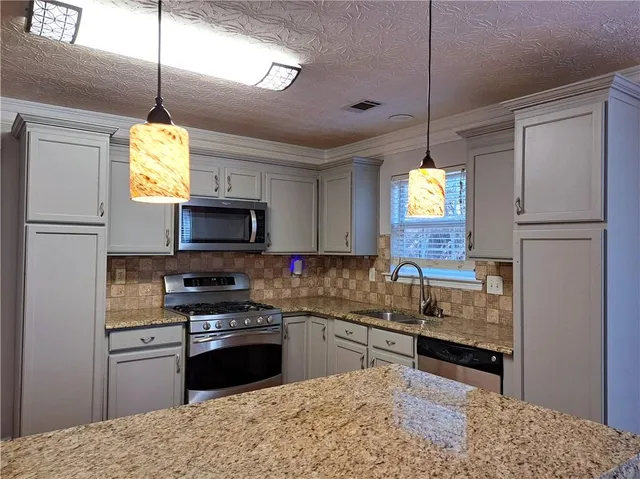 a kitchen with a refrigerator a sink stainless steel appliances and cabinets
