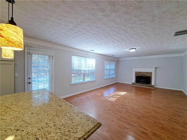 a view of empty room with wooden floor and fireplace
