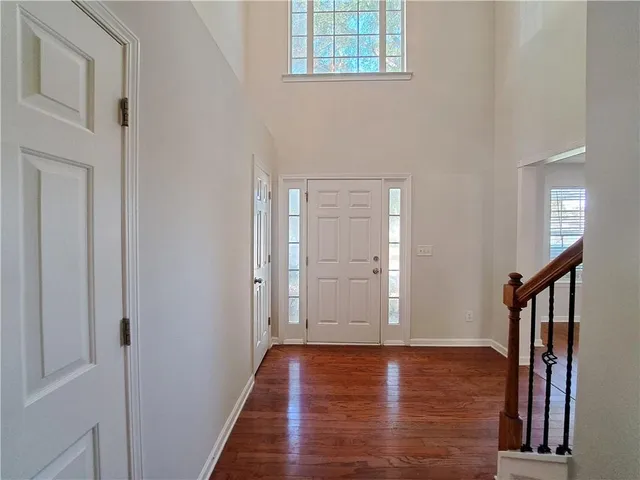 a view of a hallway with wooden floor and staircase