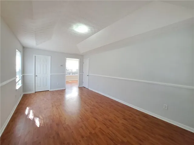 a view of empty room with wooden floor and window