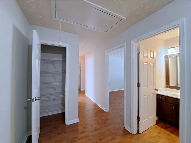 a view of a hallway with wooden floor and closet