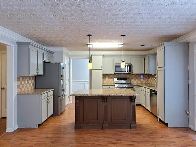 a kitchen with stainless steel appliances granite countertop a stove and refrigerator