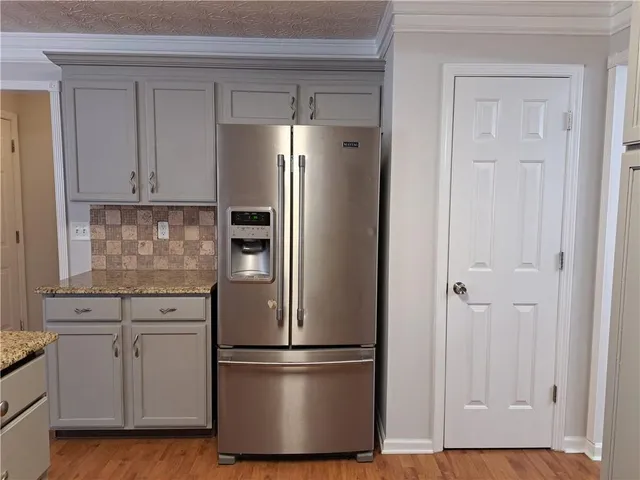 a white refrigerator freezer and a stove sitting inside of a kitchen