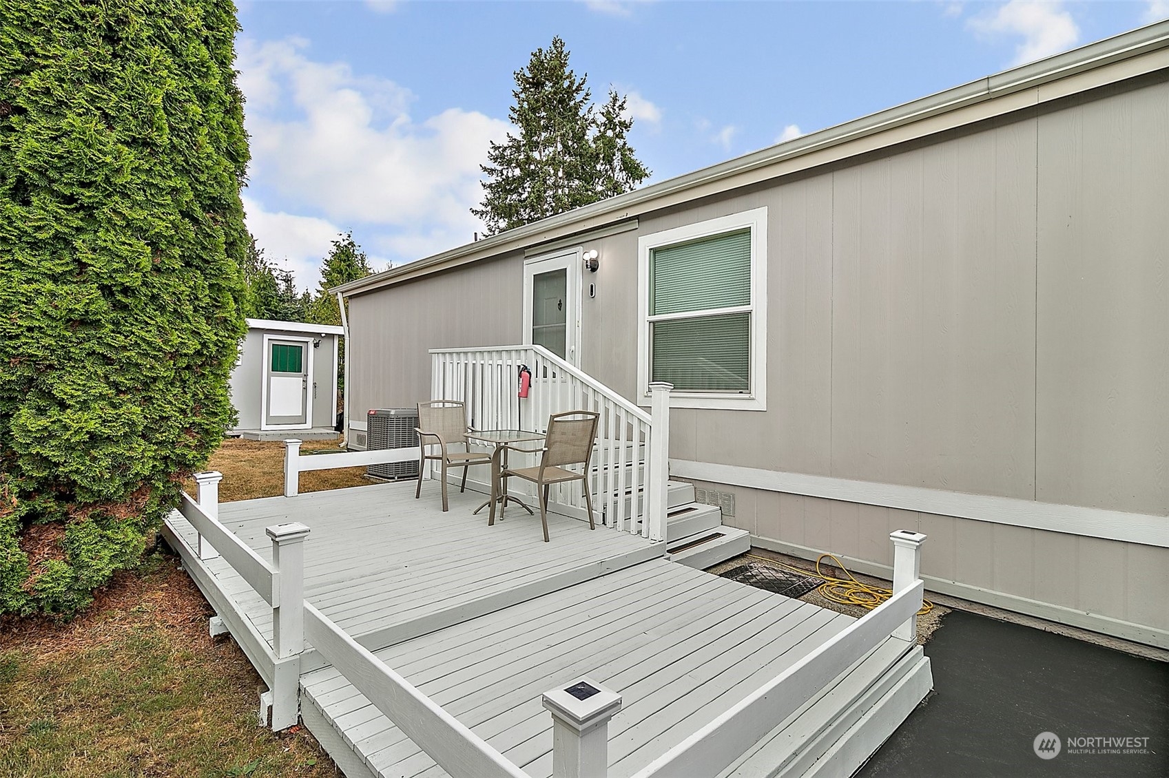 2101 South 324th Street, Unit 32 Federal Way, WA 98003 - Photo 24 of 30 a view of a patio with table and chairs with wooden floor and fence