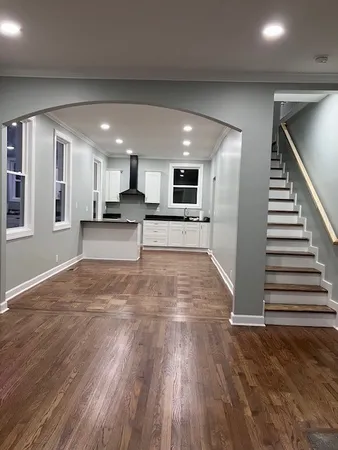 a large kitchen with cabinets and a wooden floor