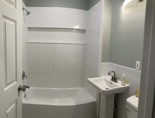 a bathroom with a sink and mirror with toilet