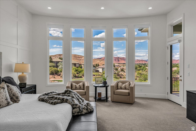 2608 Canyon Ridge Drive St. George, UT 84770 - Photo 32 of 86 Primary bedroom: expansive curved window wall presenting distant red rock formations and verdant landscapes