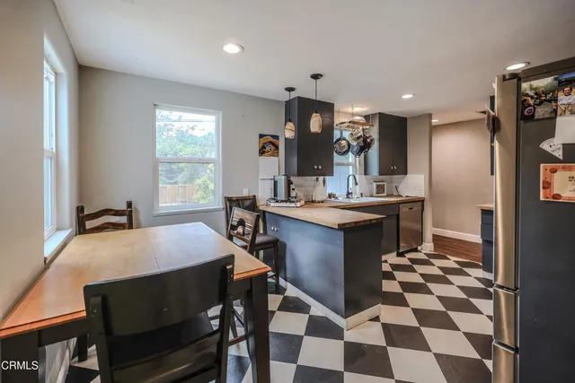 a kitchen with a sink a stove a dining table and chairs