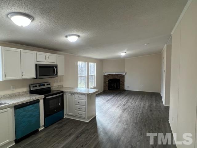 4656 Belltown Road Oxford, NC 27565 - Photo 14 of 24 a kitchen with granite countertop a stove top oven a sink dishwasher a dining table and chairs with wooden floor