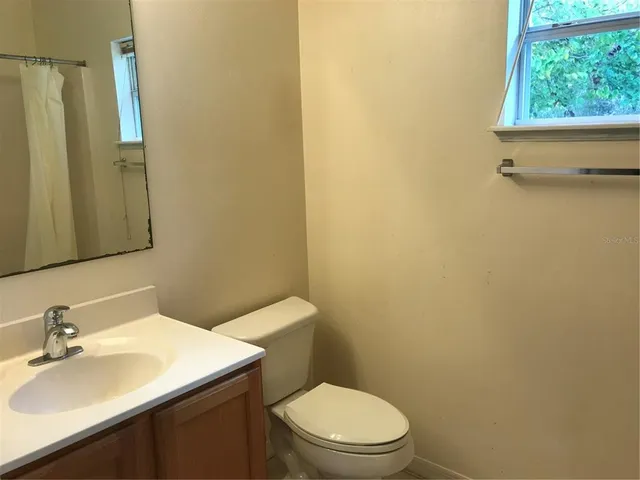 a bathroom with a sink a toilet and a mirror