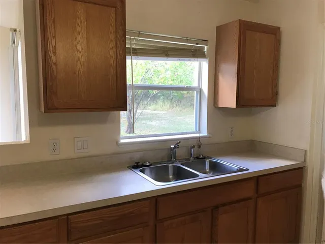 a kitchen with a sink window and cabinets