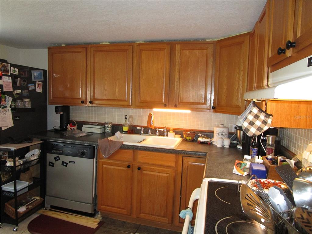 17609 Bathurst Avenue Spring Hill, FL 34610 - Photo 2 of 60 a kitchen with stainless steel appliances granite countertop a stove top oven a sink dishwasher and cabinets with wooden floor