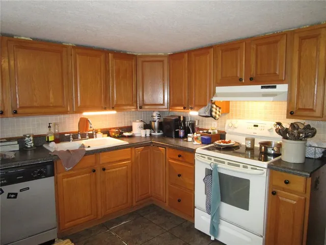 a kitchen with a sink stove top oven and cabinets