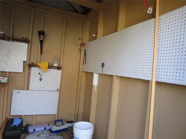 a view of a small house with a small yard and a large tree