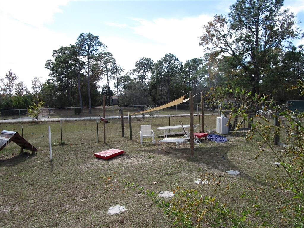 17609 Bathurst Avenue Spring Hill, FL 34610 - Photo 54 of 60 a backyard of a house with table and chairs