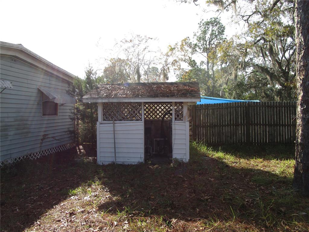 17609 Bathurst Avenue Spring Hill, FL 34610 - Photo 57 of 60 a view of a small house with a small yard and a large tree