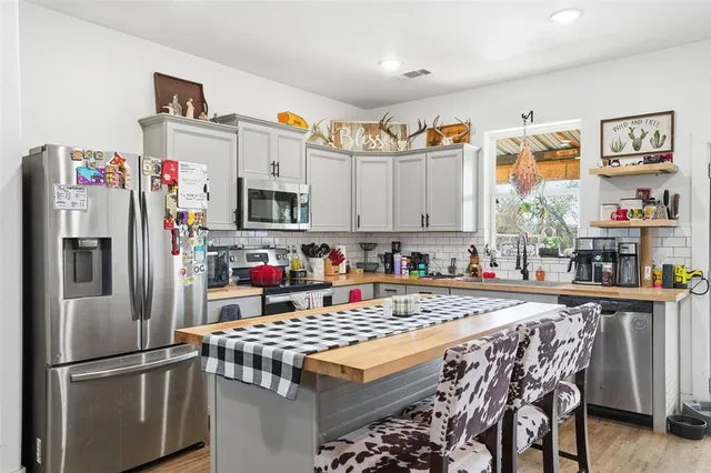 a kitchen with stainless steel appliances granite countertop a refrigerator and a stove top oven