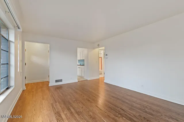 a view of empty room with wooden floor
