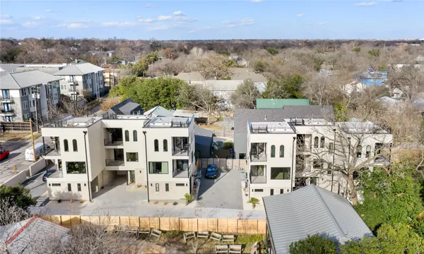 an aerial view of residential houses with outdoor space and parking