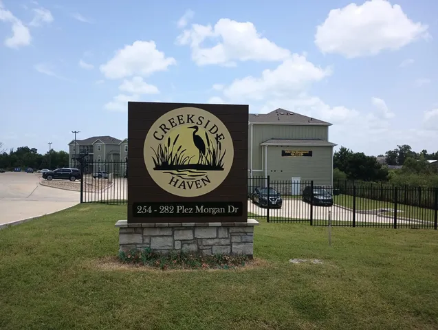 a sign that is sitting on the grass of the house