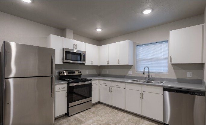 274 Plez Morgan, Unit F Montgomery, TX 77356 - Photo 10 of 13 a kitchen with stainless steel appliances granite countertop a refrigerator sink a microwave and cabinets