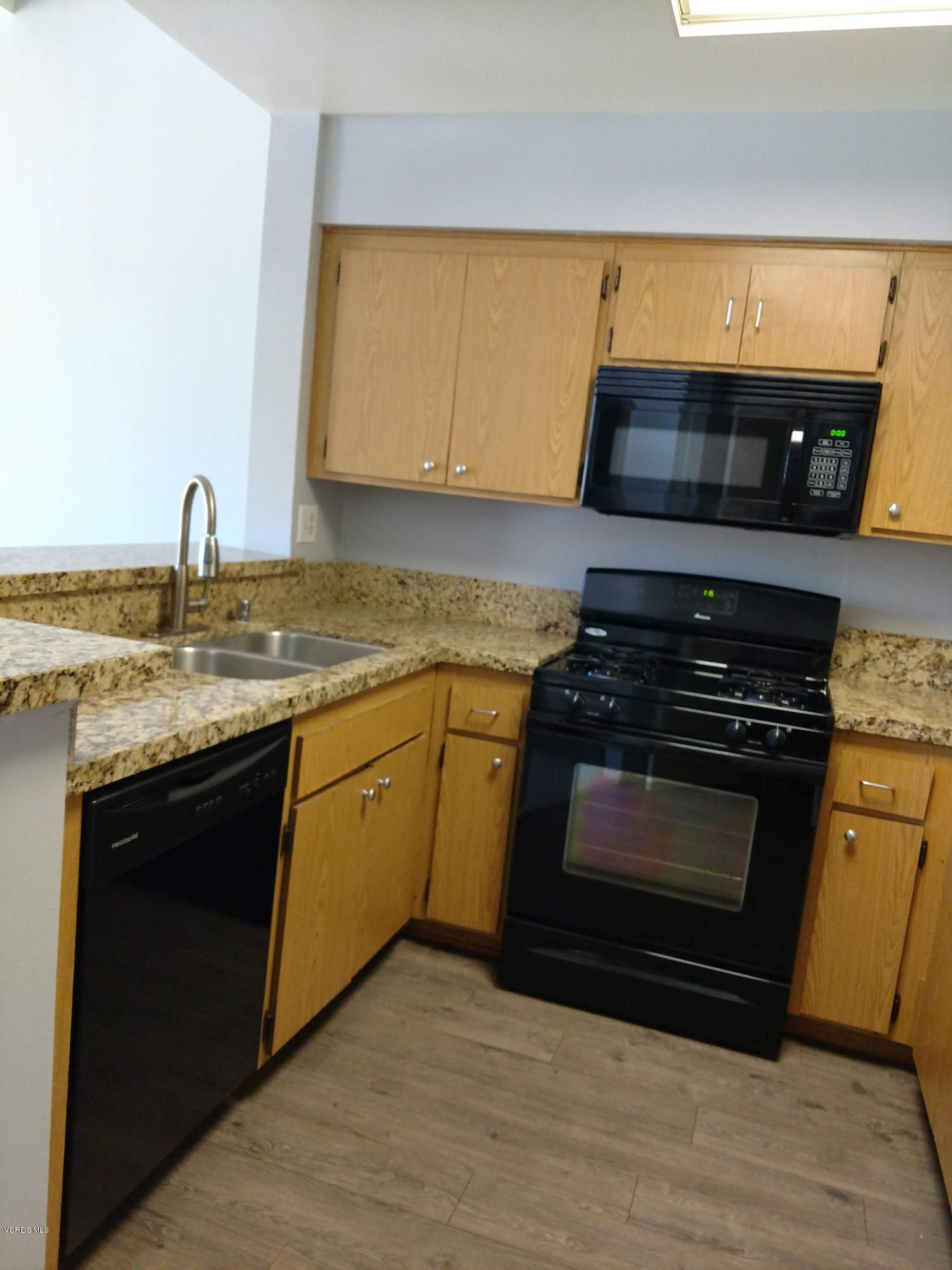 1736 Sinaloa Road, Unit 321 Simi Valley, CA 93065 - Photo 12 of 26 a kitchen with stainless steel appliances a stove a sink and a microwave