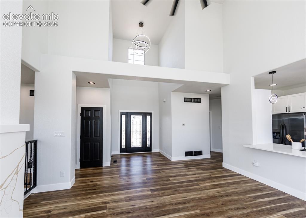1120 Newton Road Pueblo, CO 81005 - Photo 3 of 46 a view of a hallway with wooden floor and a fireplace