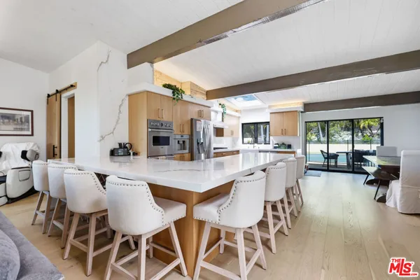 a room with a bed and a view of kitchen