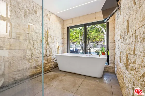 a bathroom with a double vanity sink a mirror a bathtub and shower